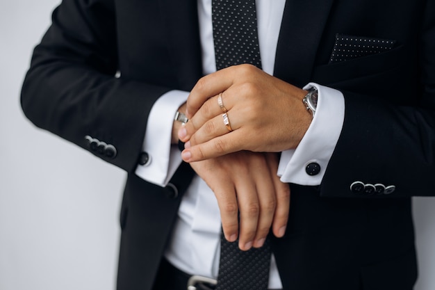 Free Photo front view of stylish man's black suit and man's hand is holding watch