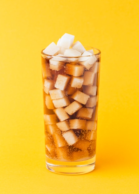 Free photo front view of sugar cubes in glass with soft drink