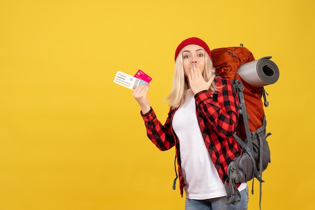 Free photo front view surprised blonde girl with her backpack holding card and travel ticket