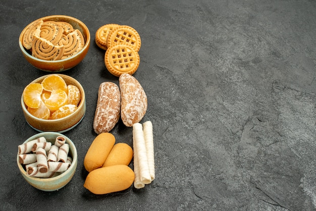 Free Photo front view sweet biscuits with cookies and fruits on grey table biscuit sweet cookie