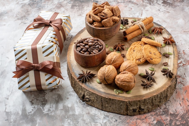 Free Photo front view sweet biscuits with presents and walnuts on light background sugar tea color cookie sweet cocoa cake love