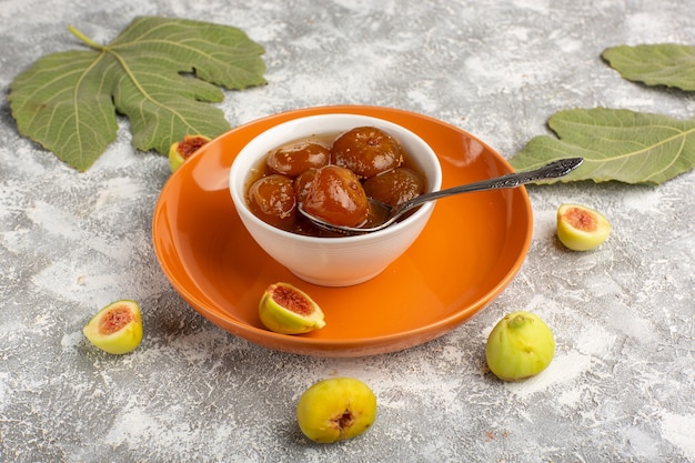 Free Photo front view sweet figs jam with fresh figs inside orange plate on white desk