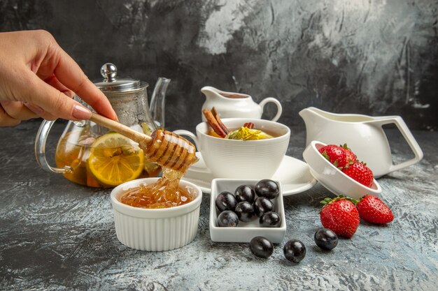 Front view sweet honey with tea and olives on dark floor morning food breakfast