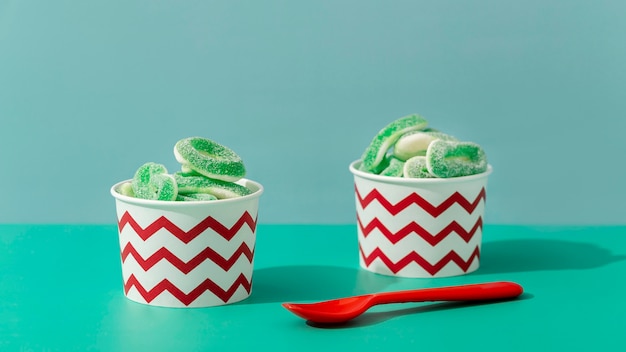 Free photo front view of sweet jelly in cups with spoon