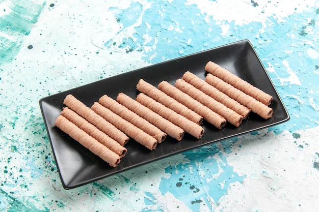 Free photo front view sweet long cookies inside black cake pan on blue surface