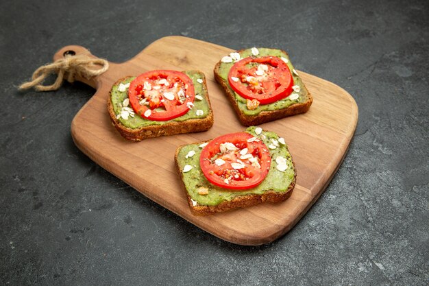 Front view tasty avocado sandwiches with sliced red tomatoes