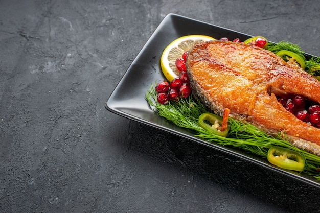 Free photo front view tasty cooked fish with greens and lemon slices inside pan on a dark background color fruit seafood food dish photo meat