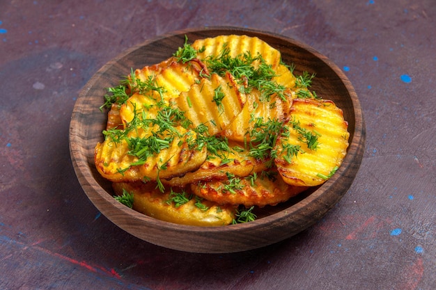 Front view tasty cooked potatoes with greens inside plate on dark surface cooking cips dinner food potato