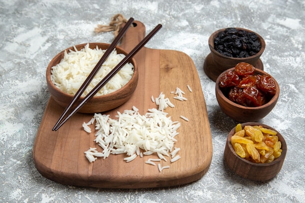 Front view tasty cooked rice inside brown plate with raisins on white space