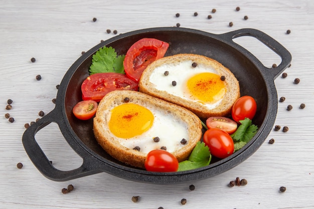 Free photo front view tasty egg toasts with tomatoes inside pan on white background breakfast lunch color salad food meal