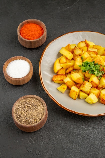 Free Photo front view tasty fried potatoes inside plate with seasonings on dark desk