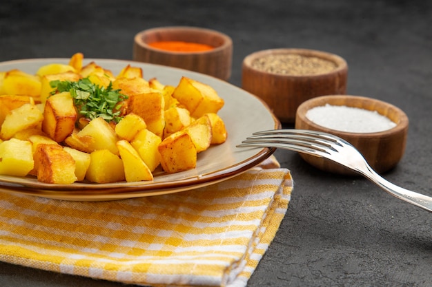 Free Photo front view tasty fried potatoes inside plate with seasonings on the dark-grey table