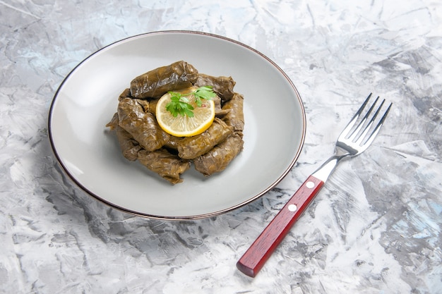 Front view of tasty leaf dolma inside plate on white surface