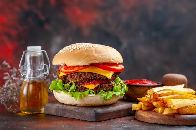 Front view tasty meat burger with french fries on dark floor