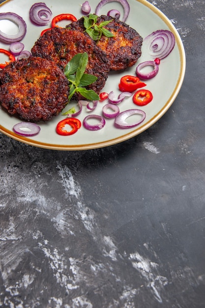 Free Photo front view tasty meat cutlets with onion rings