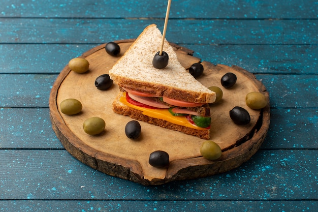 Free Photo front view tasty sandwich with cheese ham inside with olives on blue