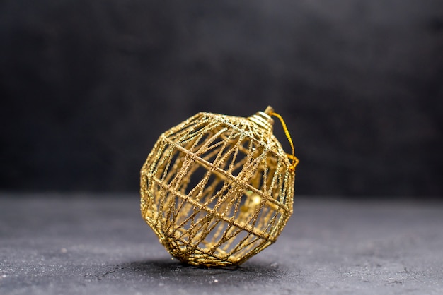 Free photo front view thread string golden xmas tree ball on dark isolated background free space