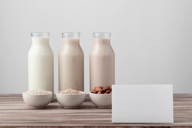 Free photo front view of three bottles with different milk