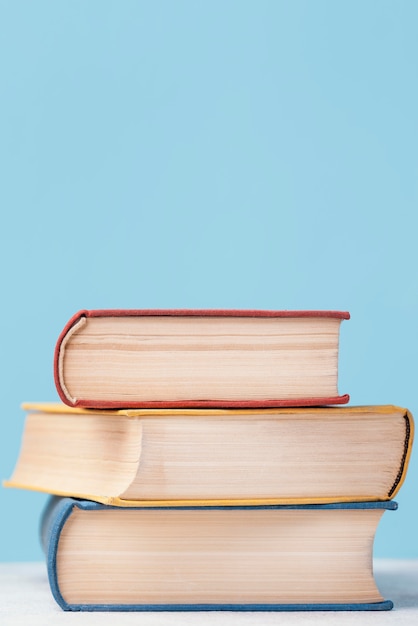 Front view of three colored stacked books with copy space