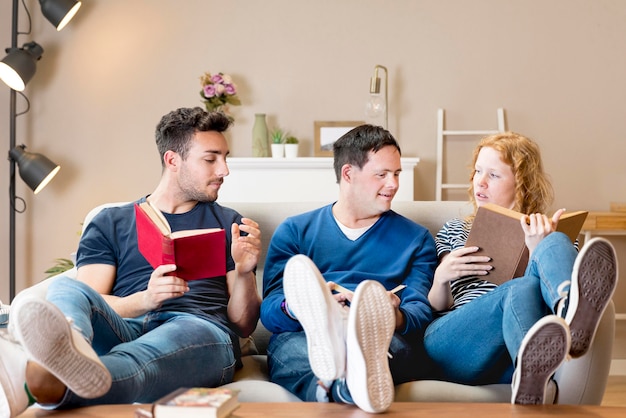 Front view of three friends on sofa with books