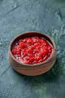 Free photo front view tomato sauce inside brown plate on a dark-blue table tomato red color seasoning pepper salt