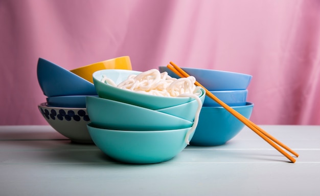 Front view towers of bowls with ramen and chopsticks