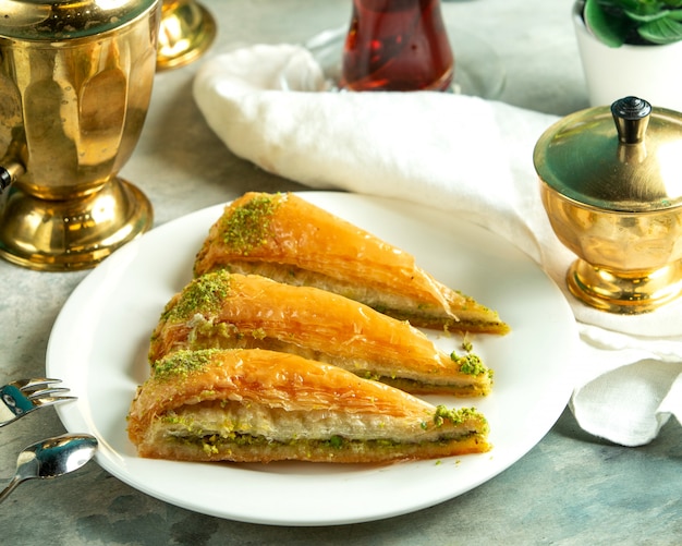 Front view traditional turkish sweetness turkish baklava with a glass of tea