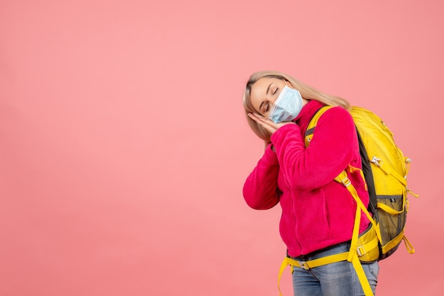 Free photo front view traveler woman with yellow backpack wearing mask sleeping