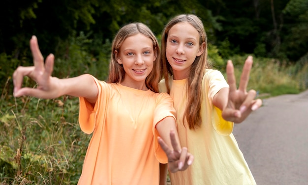 Front view twins making the peace sign