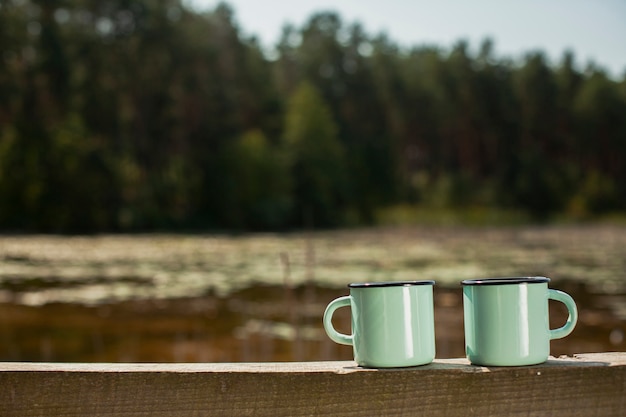 Free Photo front view two cups on wooden bridge