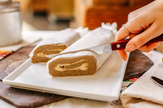 A front view vegetable pate tasty salted getting sliced by woman inside white plate rolls meal