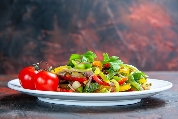 Free photo front view vegetable salad cherry tomatoes on oval plate on dark red isolated surface