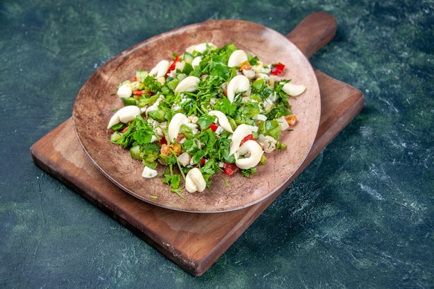 Free photo front view vegetable salad inside elegant plate on dark blue background