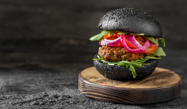 Front view veggie burger with black buns on cutting board