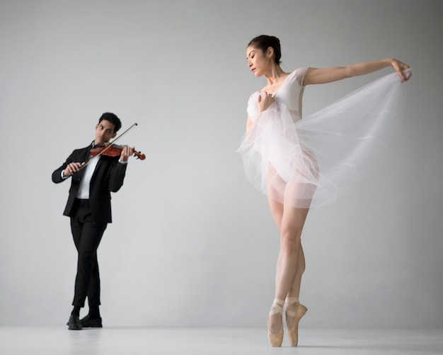 Free photo front view of violin musician with ballerina