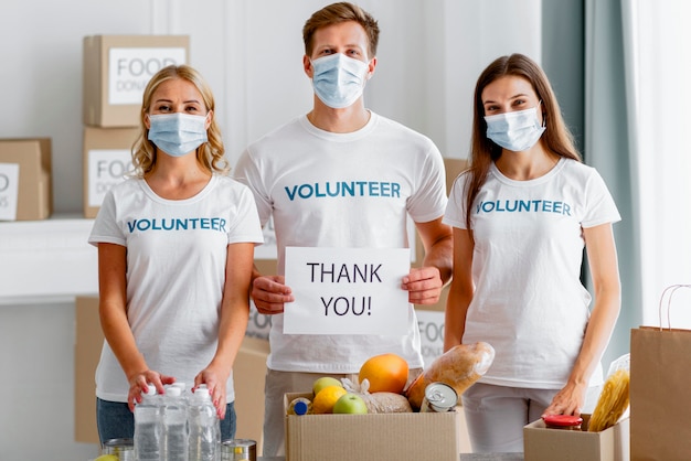 Free photo front view of volunteers thanking you for donating for food day