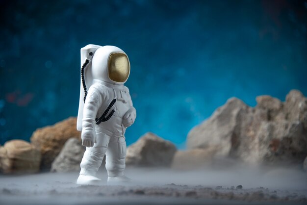 Free photo front view of white astronaut with rocks on a moon blue  sci fi fantasy cosmic