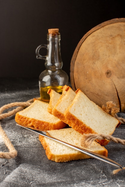 Free Photo front view white bread loafs sliced and tasty isolated with ropes and oil on grey