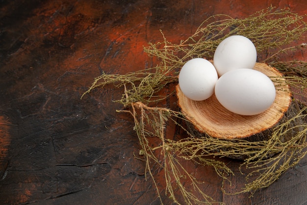 Free photo front view white chicken eggs on a dark surface