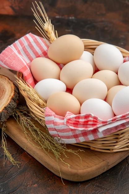 Free photo front view white chicken eggs inside basket with towel on a dark surface