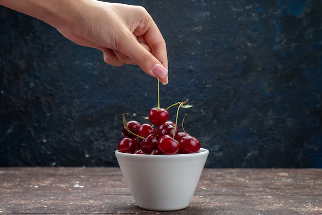 Free Photo front view white plate with sour red fresh cherries on brown wooden desk