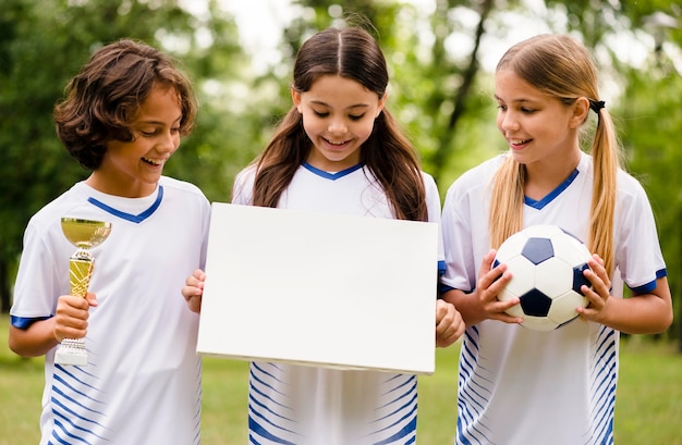 Front view winning football team holding an empty card