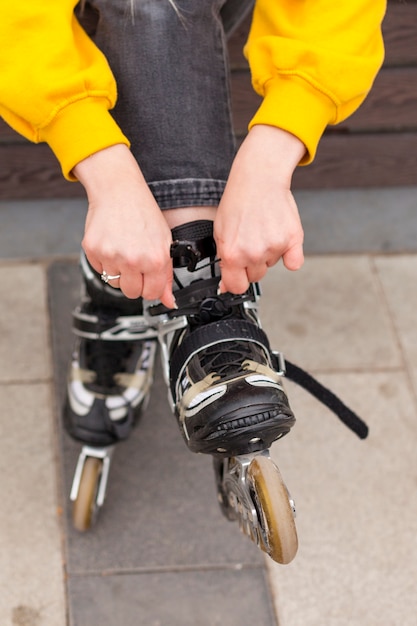 Free photo front view of woman adjusting roller blades