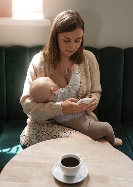 Front view woman breastfeeding baby indoors