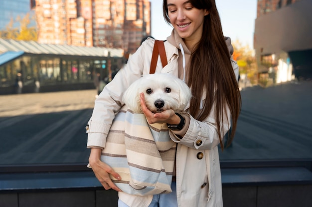 Free Photo front view woman carrying puppy in bag