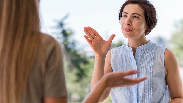 Free photo front view of woman communicating through sign language while outdoors