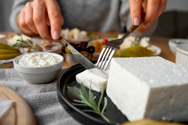 Free photo front view woman cutting cheese