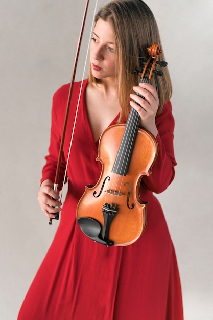 Free photo front view of woman in dress holding violin