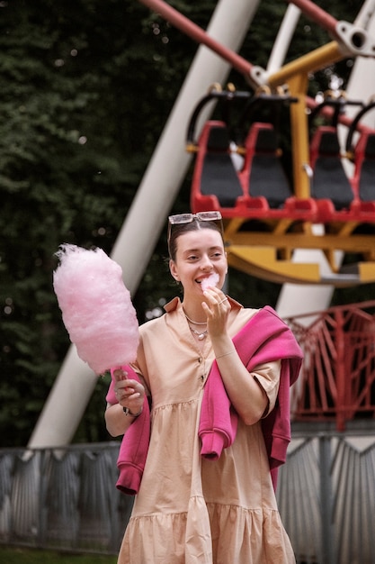 Free photo front view woman eating cotton candy