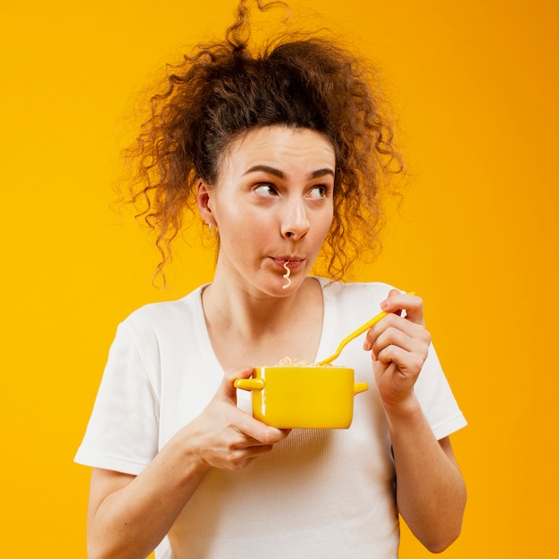 Free Photo front view of woman eating noodles